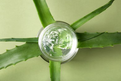 Aloe leaves and cosmetic gel on olive background, flat lay
