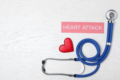 Photo of Flat lay composition with stethoscope and wooden heart on white wooden background. Space for text