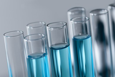 Test tubes with light blue liquid in laboratory, closeup