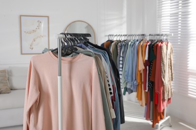 Racks with stylish clothes indoors. Fast fashion
