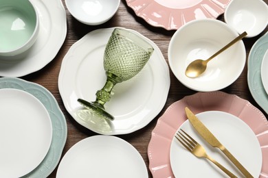 Photo of Beautiful ceramic dishware, glass and cutlery on wooden table, flat lay