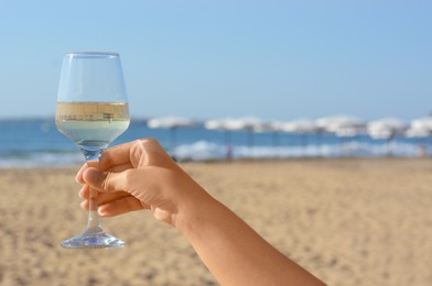 Photo of Woman with glasstasty wine near sea, closeup. Space for text