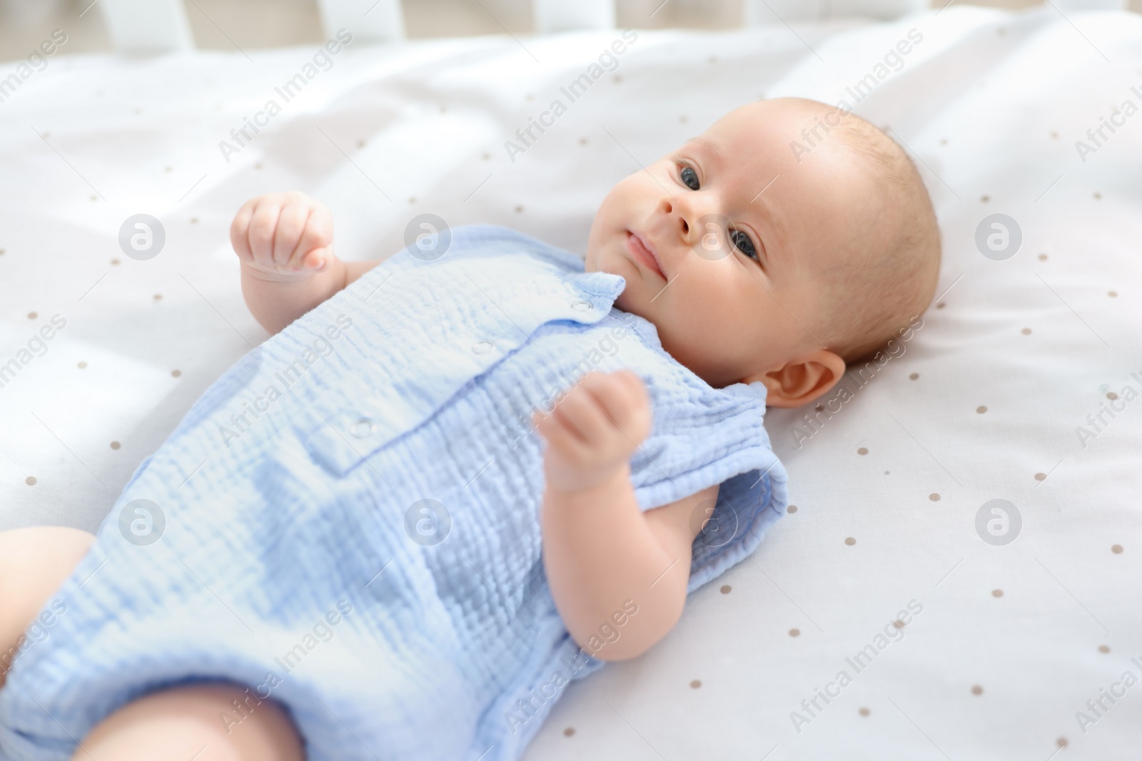 Photo of Cute little baby lying in crib at home