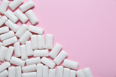 Tasty white chewing gums on pale pink background, flat lay. Space for text