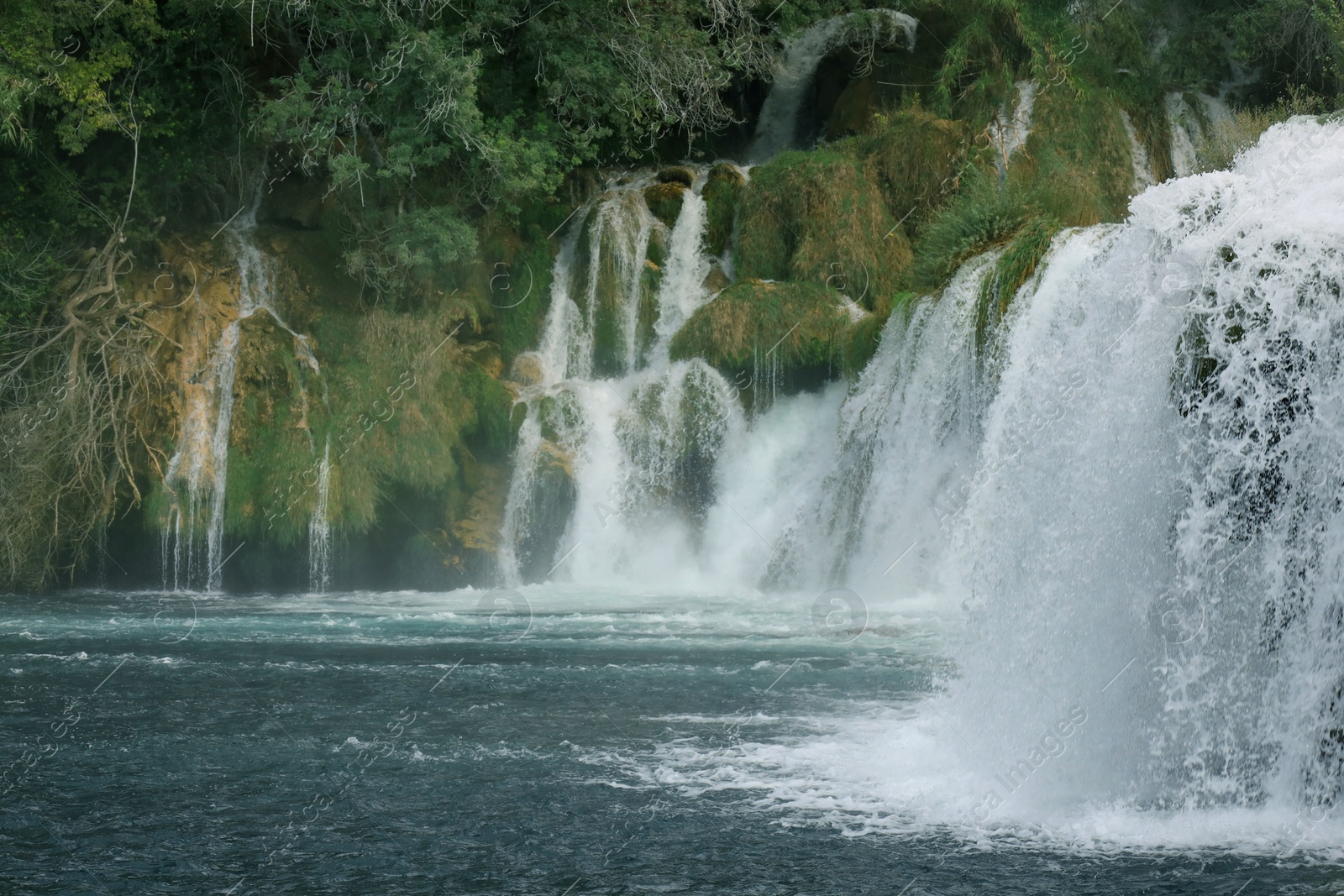 Photo of Picturesque view of beautiful waterfall and rocks outdoors