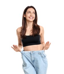 Photo of Happy young woman in big jeans showing her slim body on white background