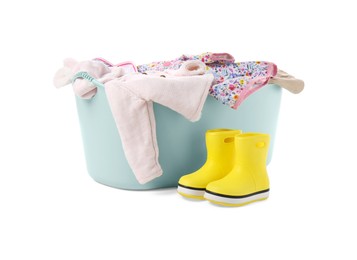 Photo of Laundry basket with baby clothes and rubber boots isolated on white