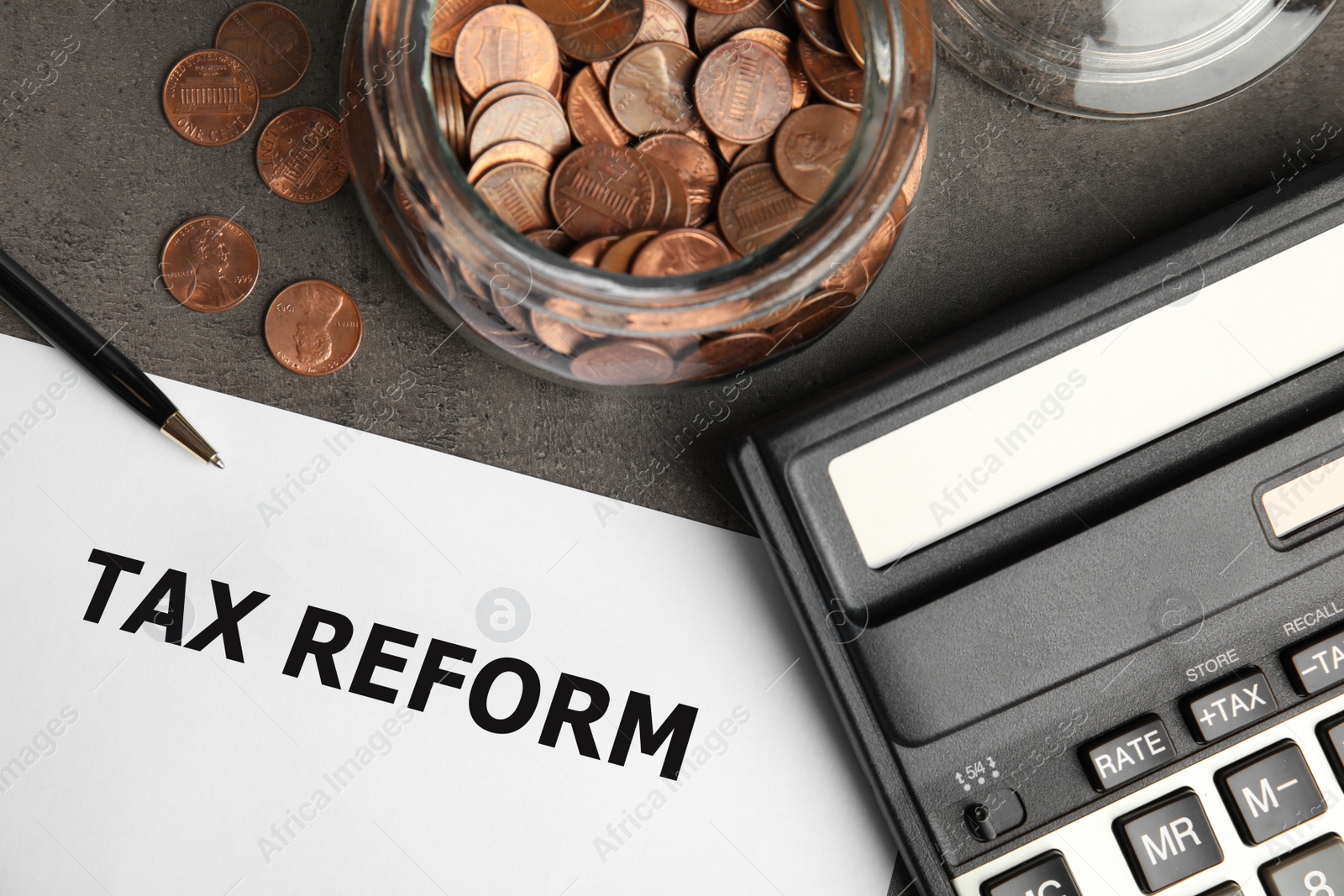 Image of Paper with words TAX REFORM, coins, jar, calculator and pen on table, flat lay