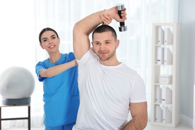 Photo of Doctor working with patient in hospital. Rehabilitation exercises