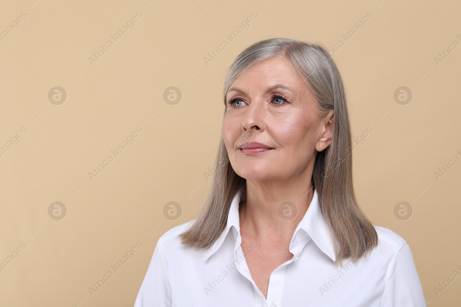 Photo of Portrait of beautiful senior woman on beige background. Space for text