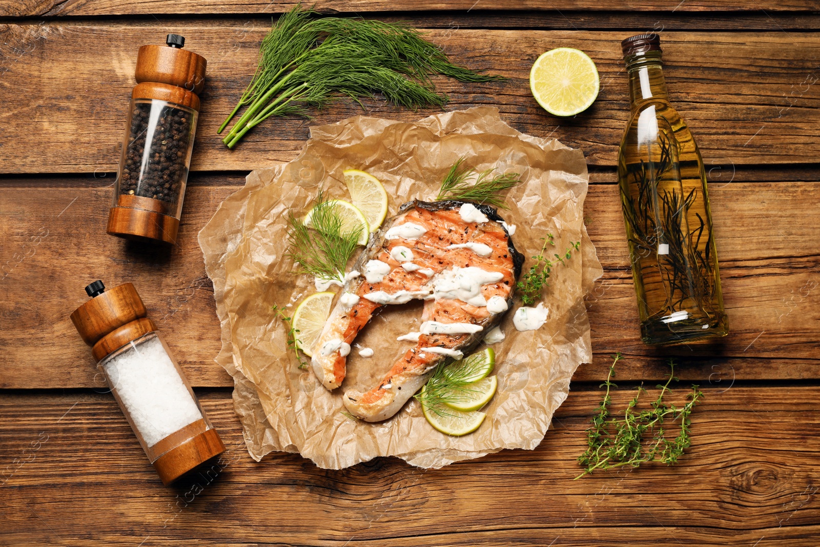 Photo of Tasty salmon steak with sauce, spices and oil on wooden table, flat lay