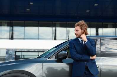 Photo of Attractive young man near luxury car outdoors