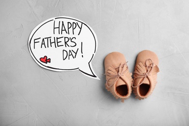 Photo of Flat lay composition with baby shoes on gray background. Happy Father's Day