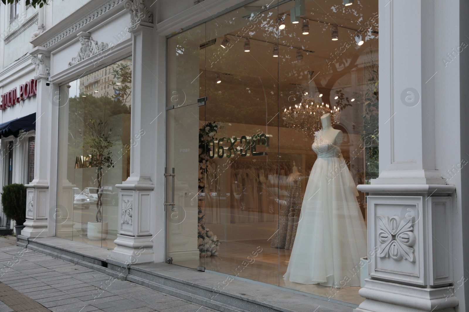 Photo of Showcase with beautiful wedding dress on mannequin