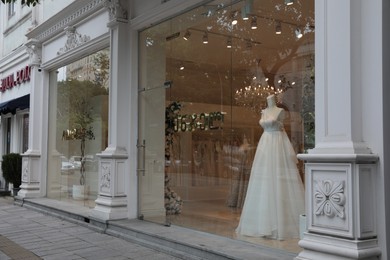 Showcase with beautiful wedding dress on mannequin