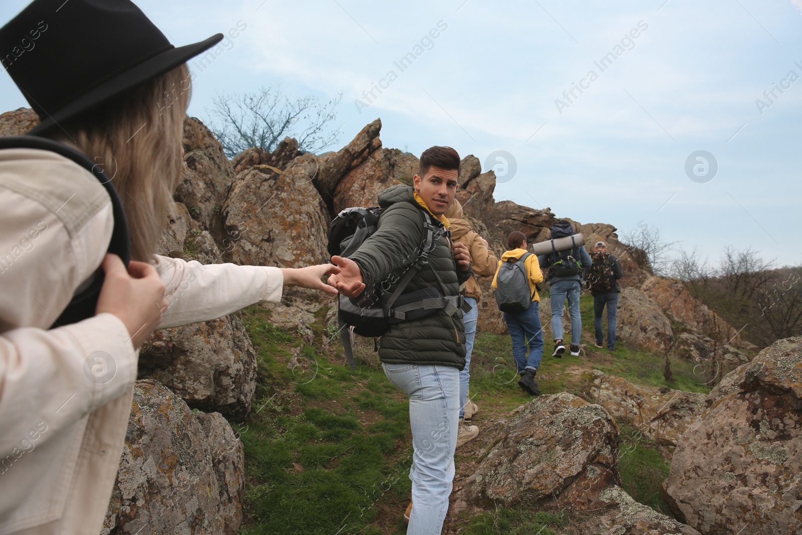 Photo of Group of hikers with backpacks climbing up mountains