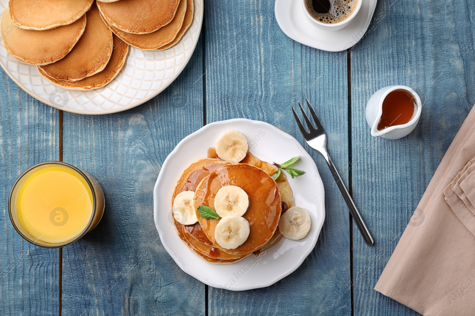 Photo of Flat lay composition with tasty pancakes and glass of juice on wooden background