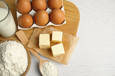 Fresh ingredients for delicious homemade cake on white wooden table