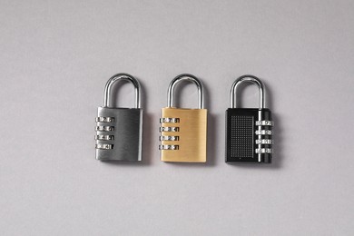 Steel combination padlocks on grey background, top view
