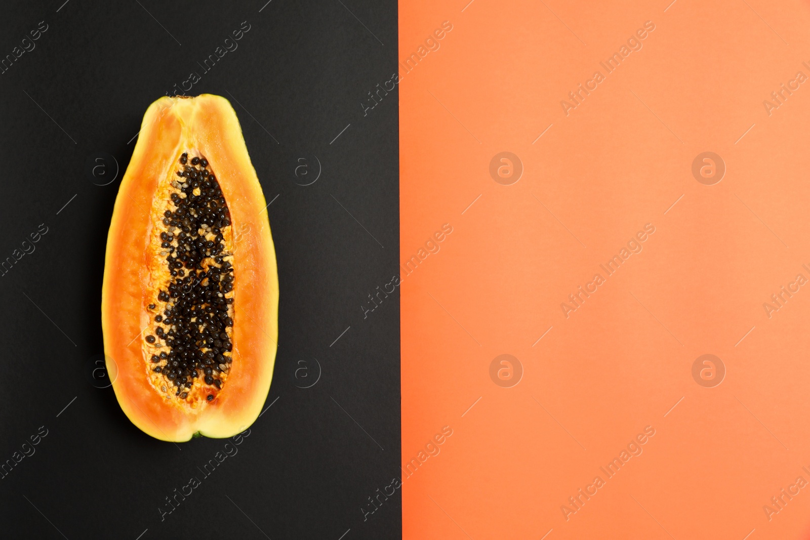 Photo of Fresh juicy halved papaya on color background, top view. Space for text