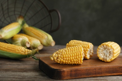 Photo of Tasty sweet corn cob on wooden board