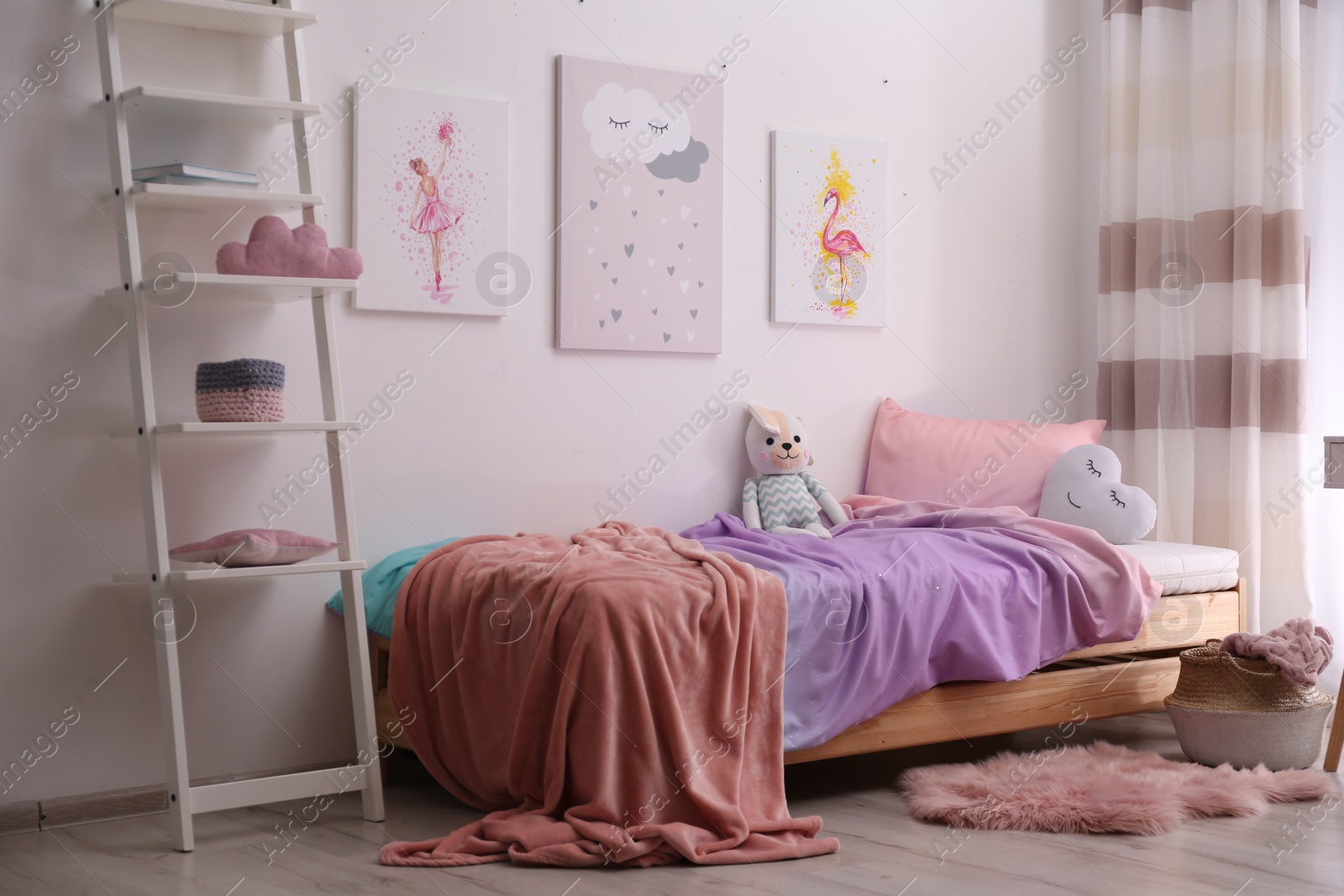 Photo of Comfortable bed with pink linens in children's room