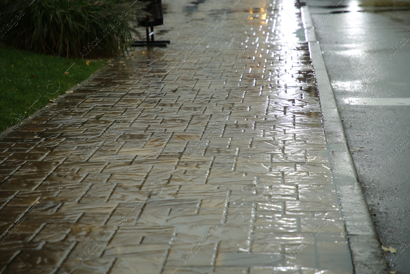 Photo of City street with puddles on pavement after rain