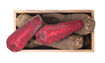 Photo of Whole and cut red beets in wooden crate isolated on white, top view