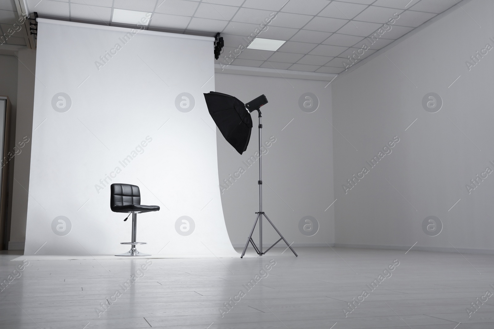 Photo of Photo studio interior with modern chair and professional lighting equipment