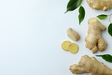 Photo of Fresh ginger with green leaves on white background, flat lay. Space for text