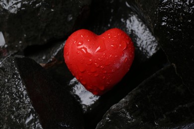 Photo of Red decorative heart on stones, top view