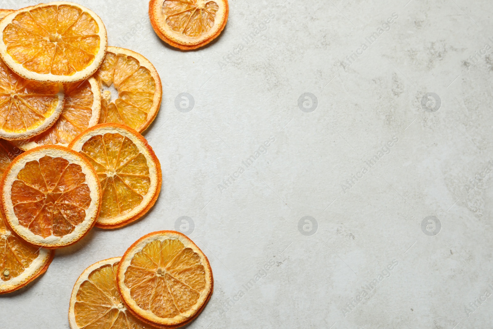 Photo of Dry orange slices on light grey table, flat lay. Space for text