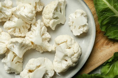 Photo of Cut fresh raw cauliflowers on wooden board, top view