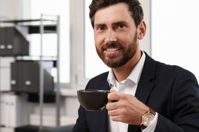 Photo of Smiling bearded man with cupdrink indoors