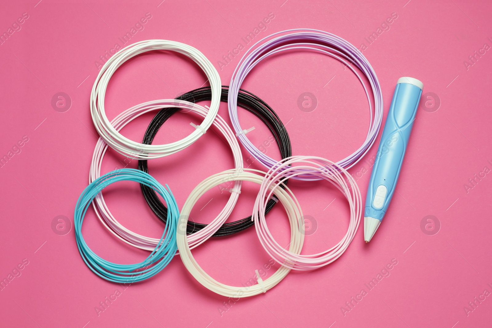 Photo of Stylish 3D pen and colorful plastic filaments on pink background, flat lay