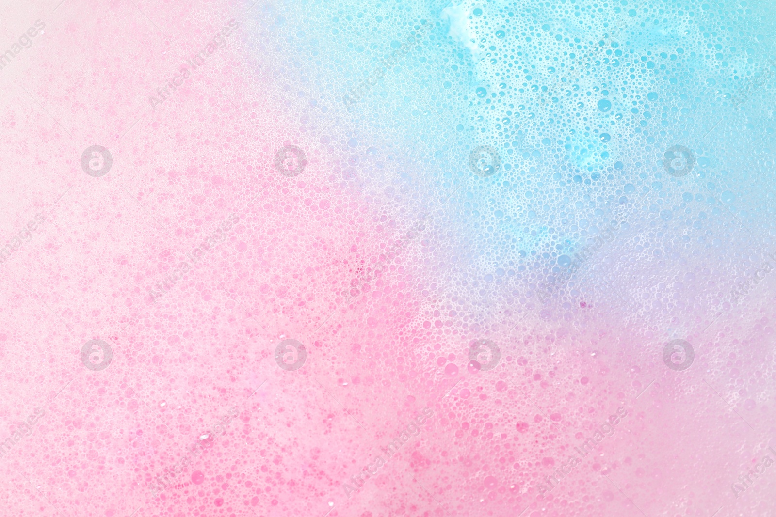 Photo of Colorful foam after dissolving bath bomb in water, closeup