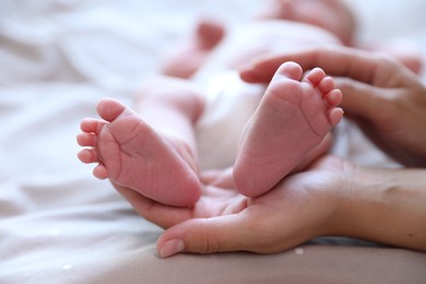 Photo of Mother and her newborn baby on bed, closeup