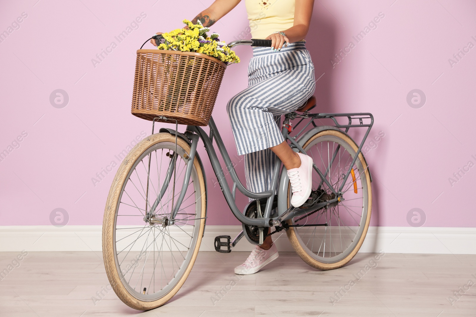 Photo of Young woman with bicycle near color wall