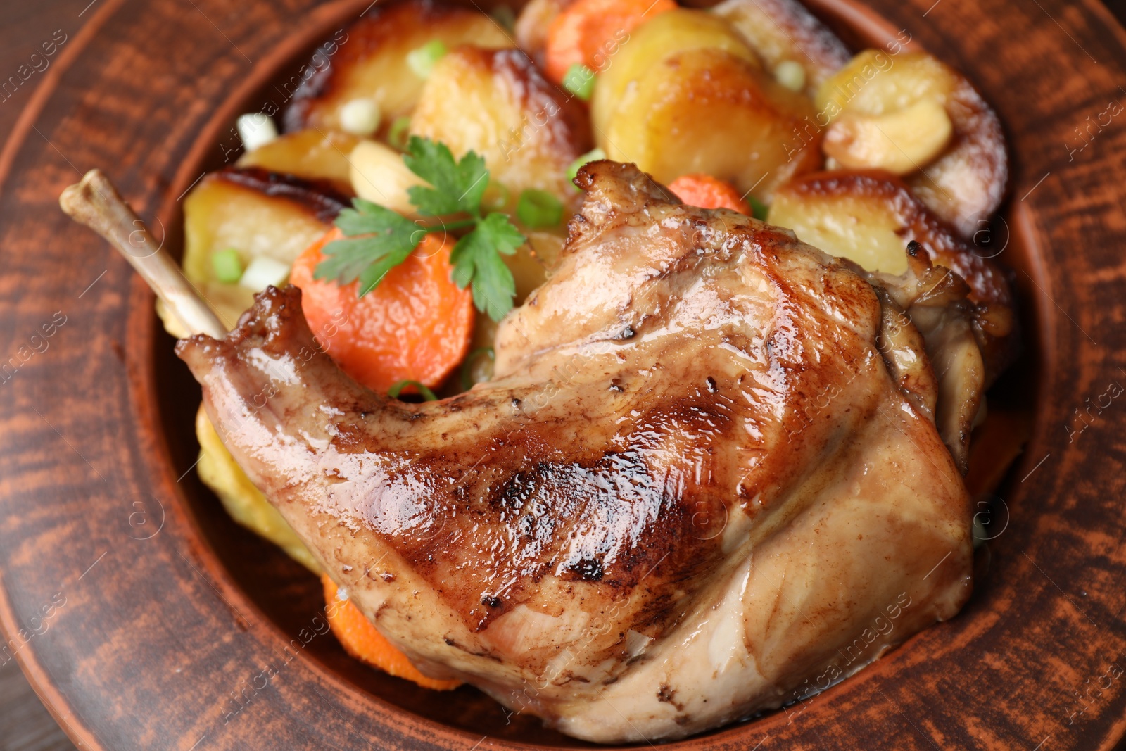 Photo of Tasty cooked rabbit meat with vegetables in bowl, closeup