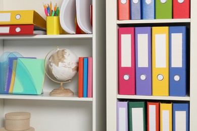 Colorful binder office folders and other stationery on shelving unit