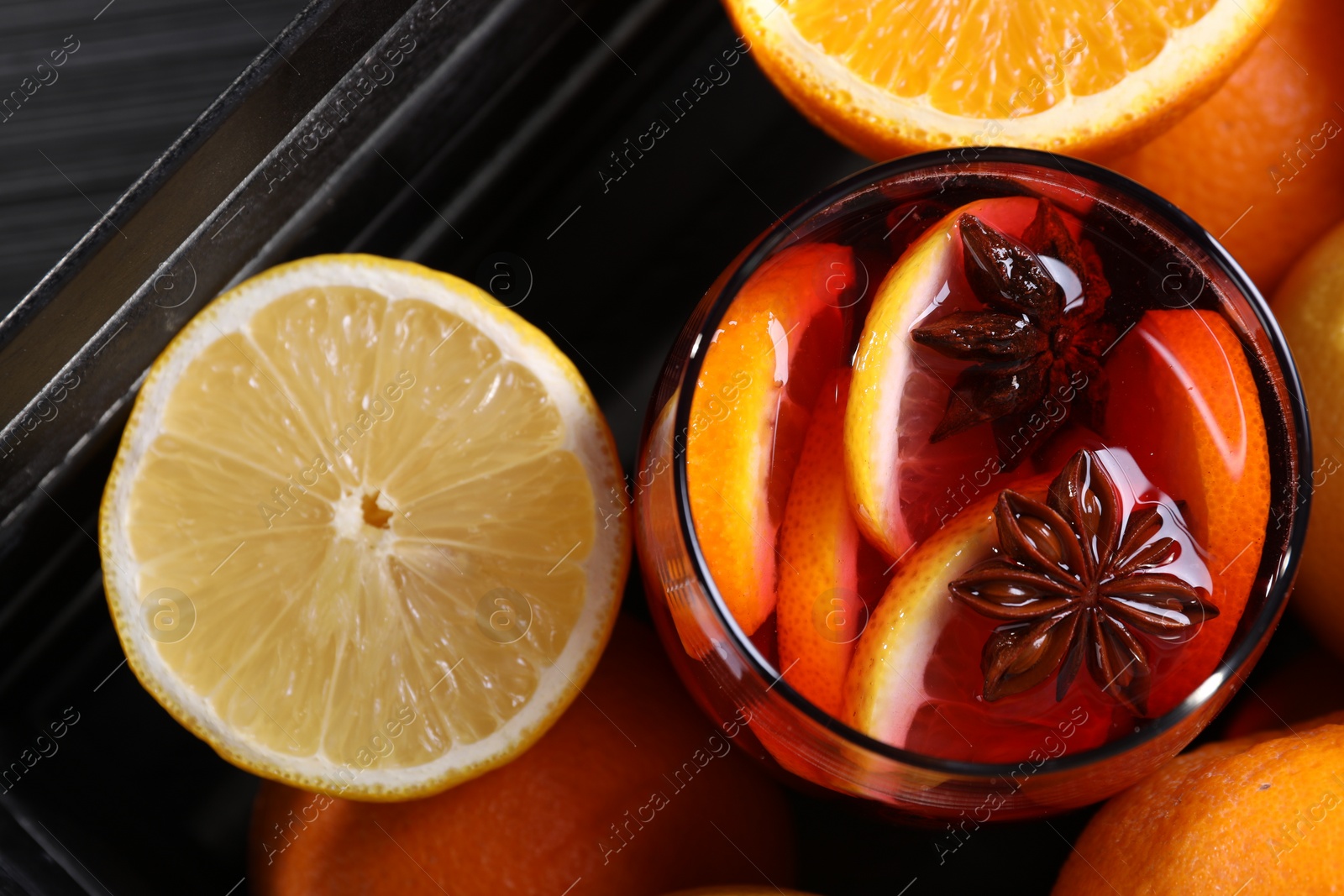 Photo of Glass of aromatic punch drink and fresh citrus fruits on table, flat lay