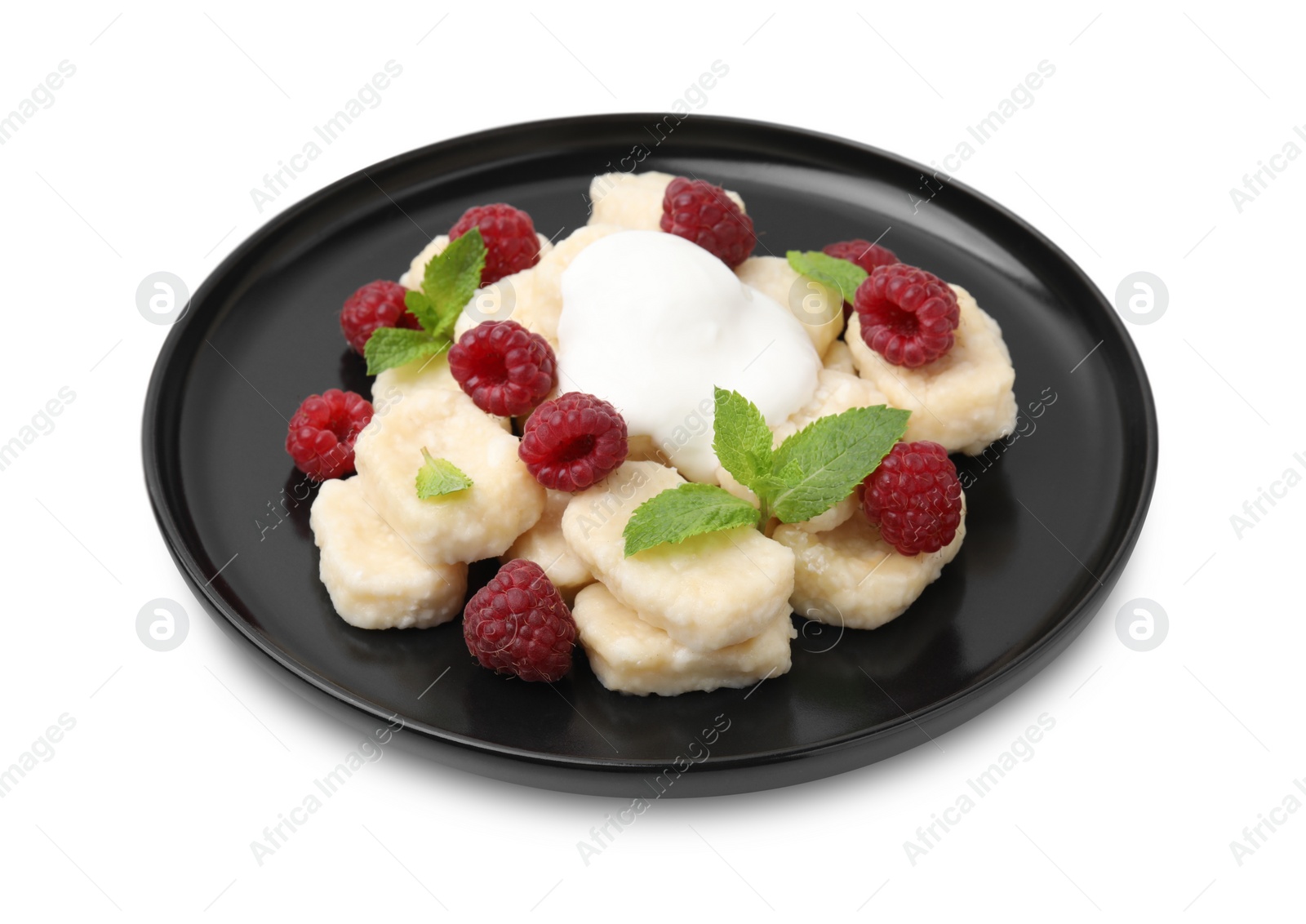 Photo of Plate of tasty lazy dumplings with raspberries, sour cream and mint leaves isolated on white
