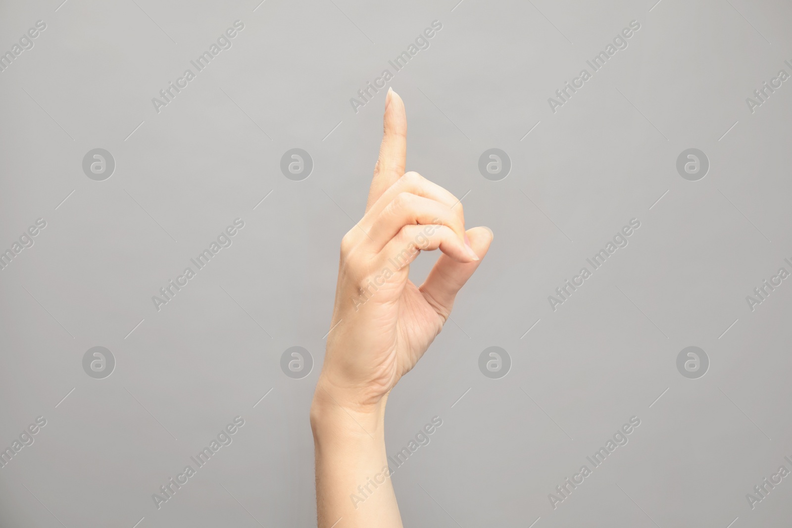 Photo of Woman showing D letter on grey background, closeup. Sign language