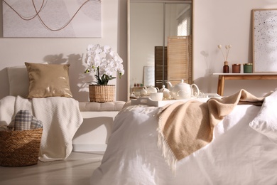 Beautiful bedroom interior with potted white orchids