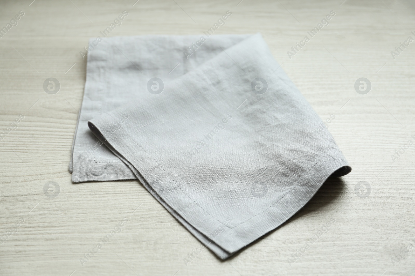 Photo of Light folded napkin on white wooden table