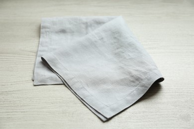 Light folded napkin on white wooden table