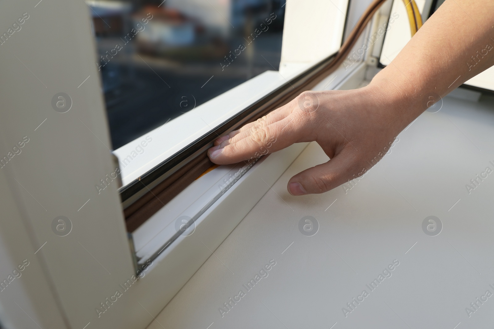 Photo of Construction worker putting sealing foam tape on window, closeup