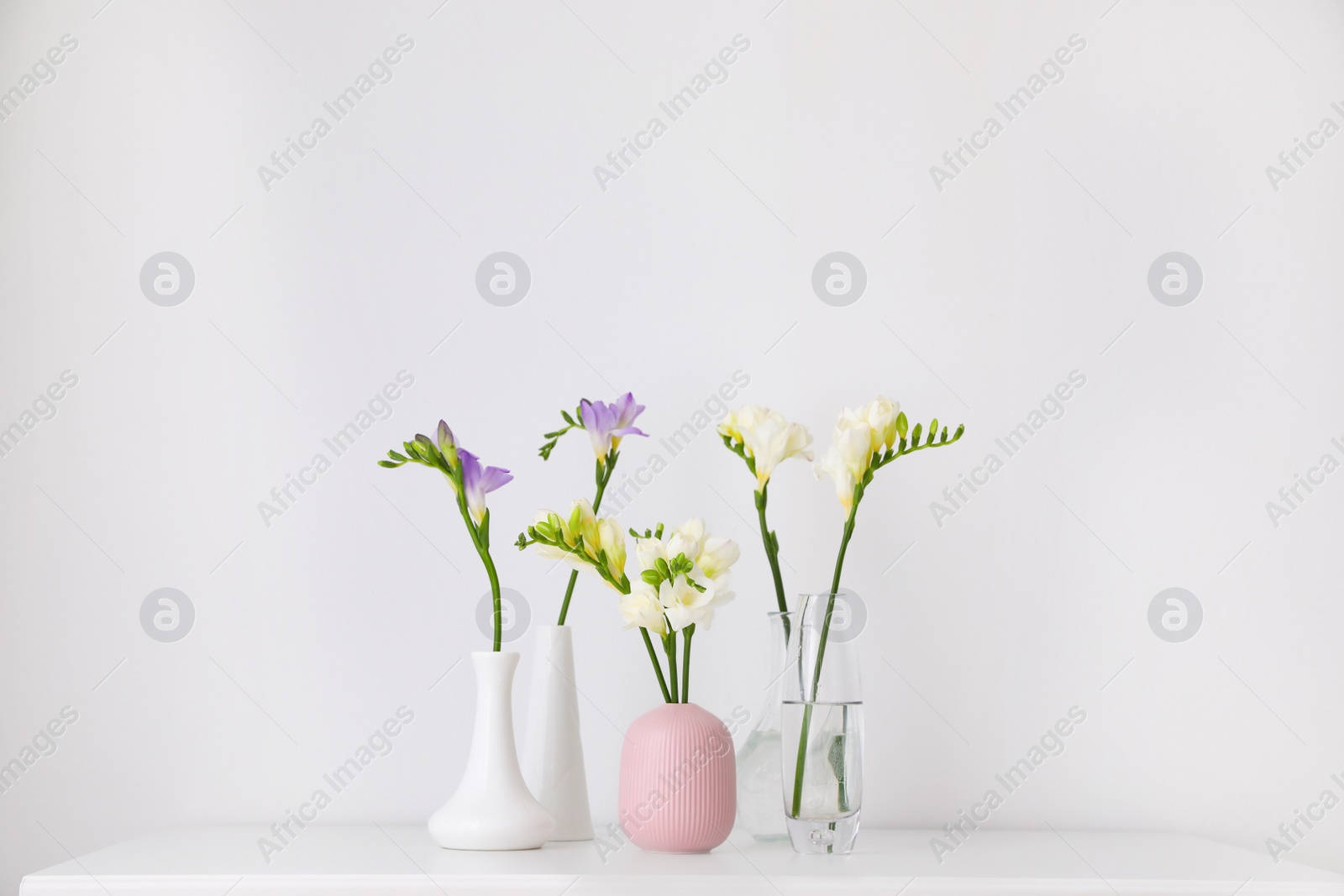 Photo of Beautiful spring freesia flowers on white table