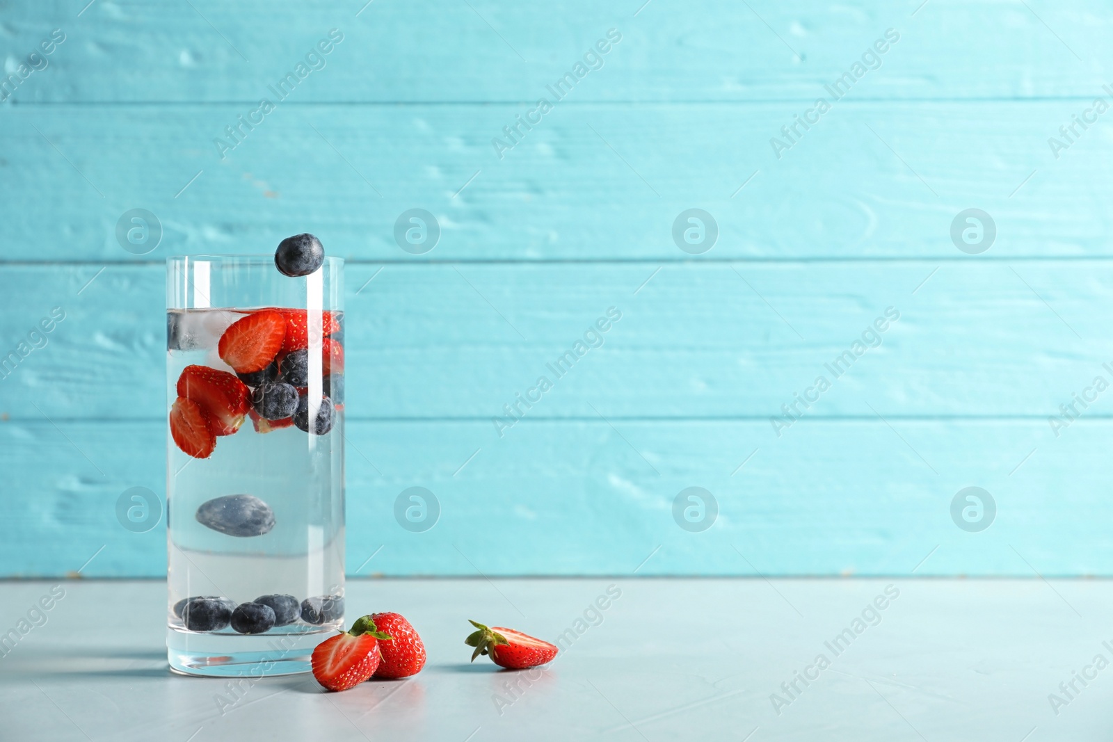 Photo of Natural lemonade with berries in glass on table