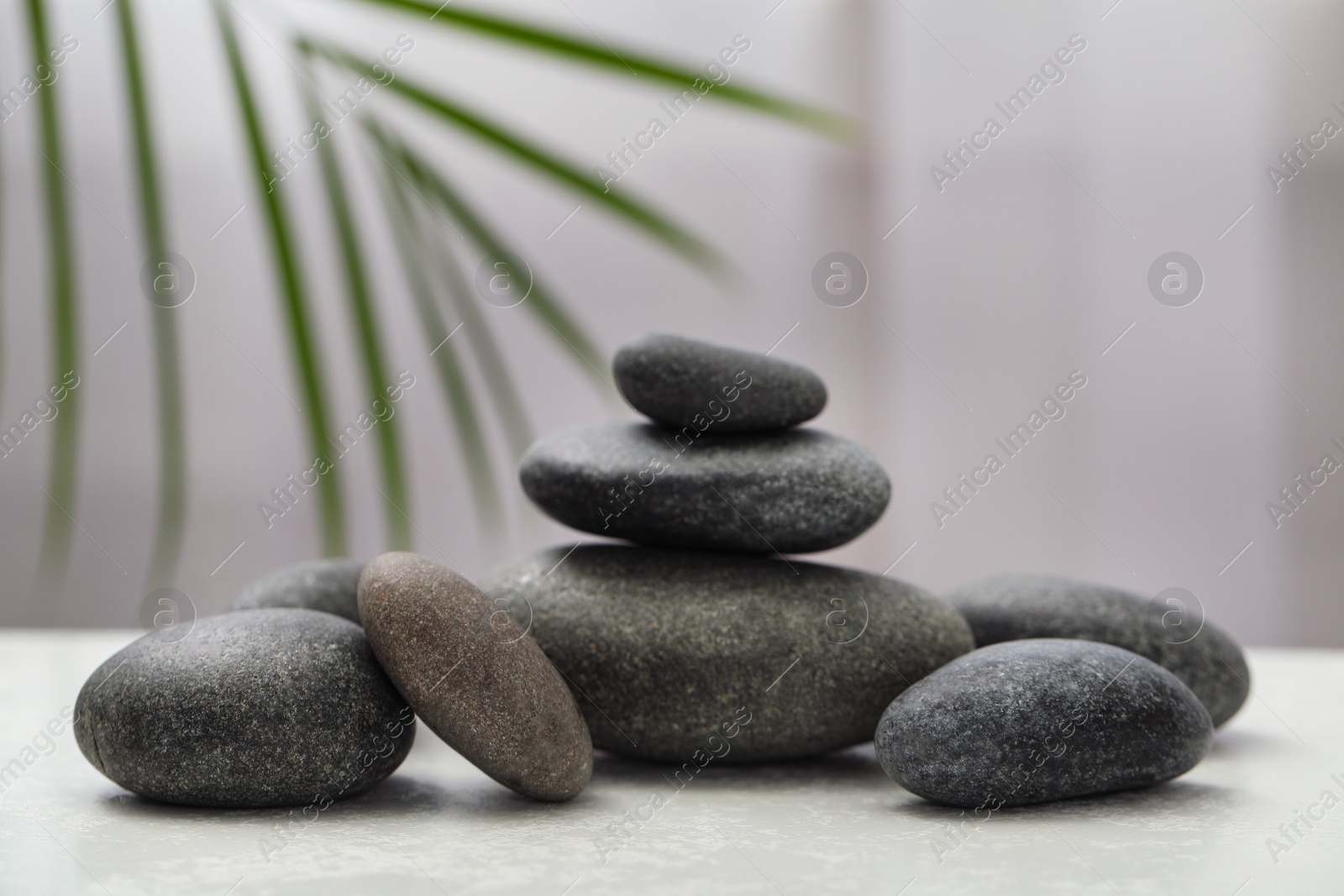 Photo of Spa stones on white table indoors. Zen and harmony